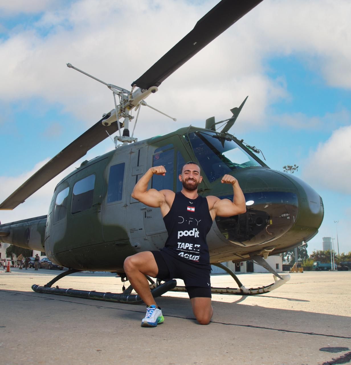 Samer beside a helicopter